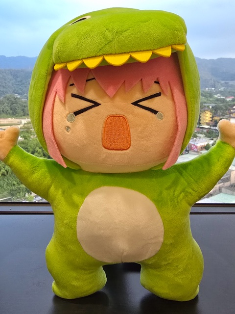 山の見える場所で恐竜の着ぐるみを着たぬいぐるみ